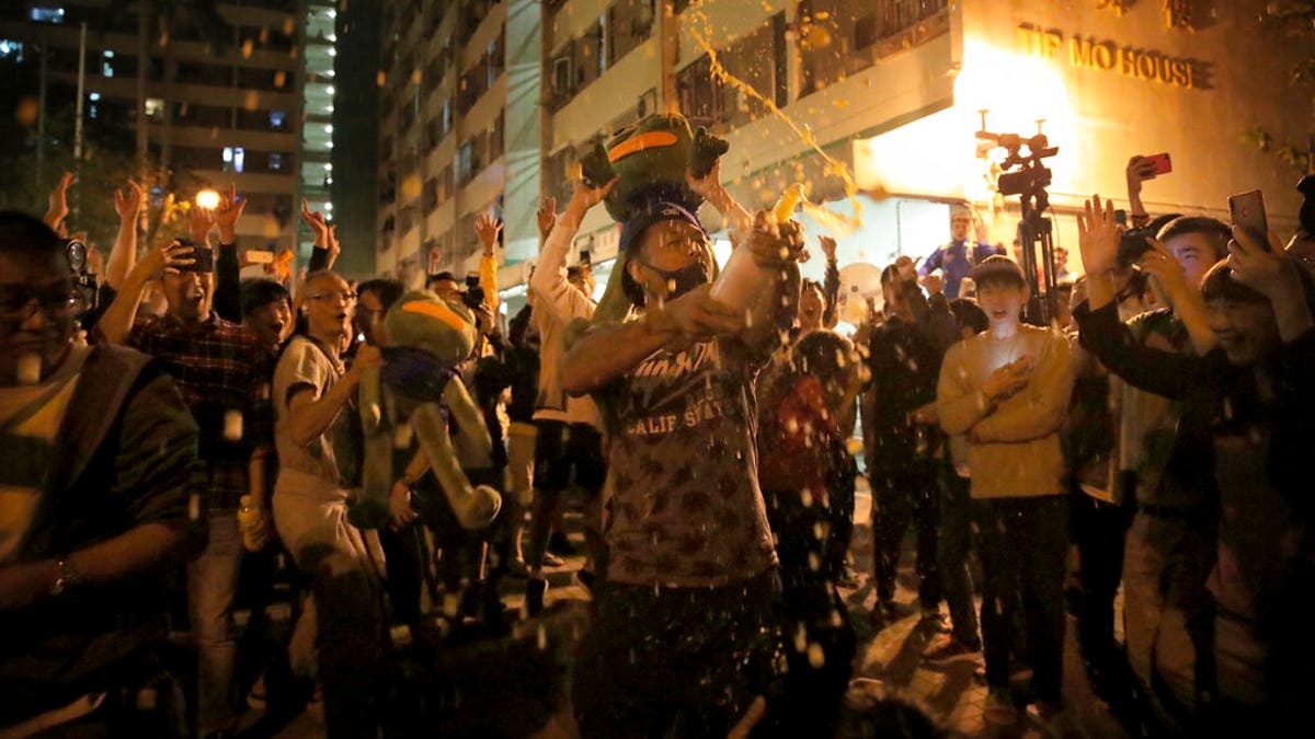 Pro-democracy supporters celebrating after pro-Beijing politician Junius Ho lost his election in Hong Kong, early Monday. (AP Photo/Kin Cheung)