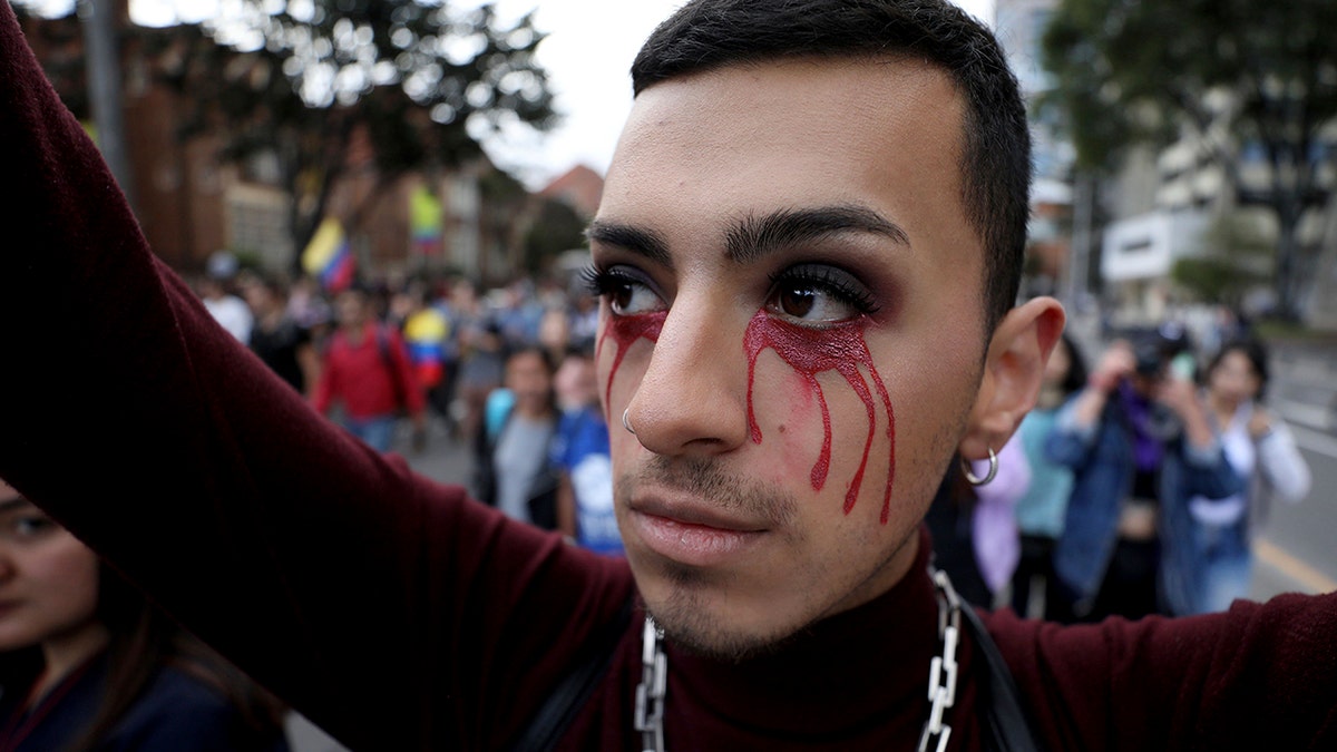 An anti-government demonstrator with red tears painted on his face joins protest in Bogota, Colombia, Monday, Nov. 25, 2019. (AP Photo/Fernando Vergara)