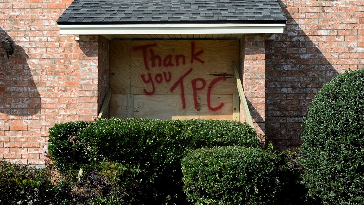 A boarded up window bears a message for TPC Group as residents and business owners throughout Port Neches, Texas clean up from the damage caused by an explosion on Wednesday. Three workers were injured early Wednesday in a massive explosion at the Texas chemical plant that also blew out the windows and doors of nearby homes. (Kim Brent/The Beaumont Enterprise via AP)