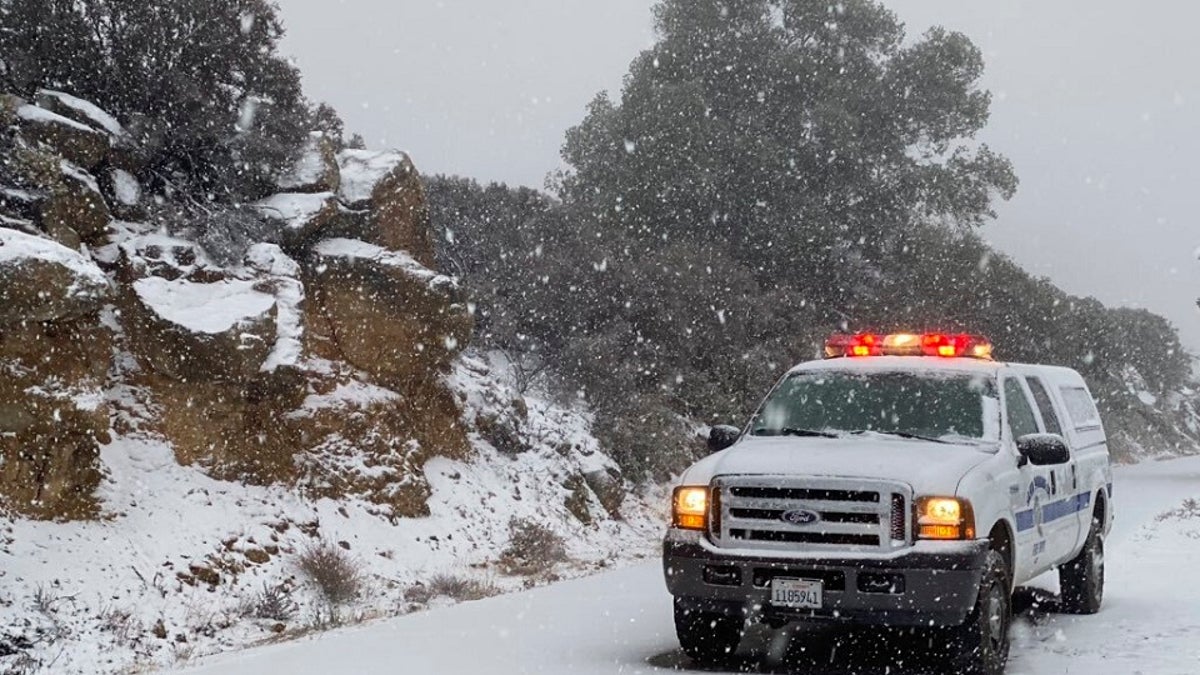 This photo tweeted by the Santa Barbara County Fire Department shows a Santa Barbara Fire Department truck along E. Camino Cielo as snow falls at the 3,500 foot level on the fire footprint in Santa Barbara, Calif. Thursday, Nov. 28, 2019. Wintry weather temporarily loosened its grip across much of the U.S. just in time for Thanksgiving, after tangling holiday travelers in wind, ice and snow and before more major storms descend Friday. (Mike Eliason/Santa Barbara County Fire via AP)