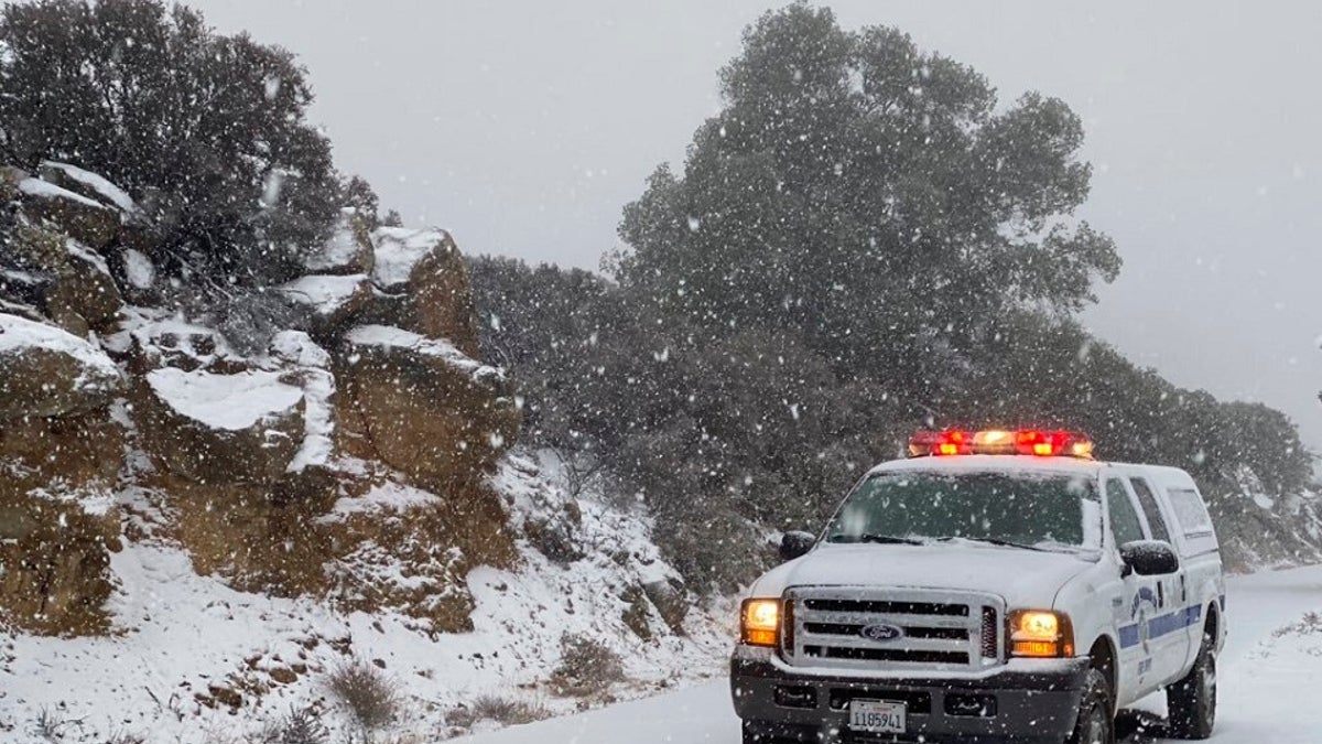 This photo tweeted by the Santa Barbara County Fire Department shows a Santa Barbara Fire Department truck along E. Camino Cielo as snow falls at the 3,500 foot level on the fire footprint in Santa Barbara, Calif. Thursday, Nov. 28, 2019. Wintry weather temporarily loosened its grip across much of the U.S. just in time for Thanksgiving, after tangling holiday travelers in wind, ice and snow and before more major storms descend Friday. (Mike Eliason/Santa Barbara County Fire via AP)