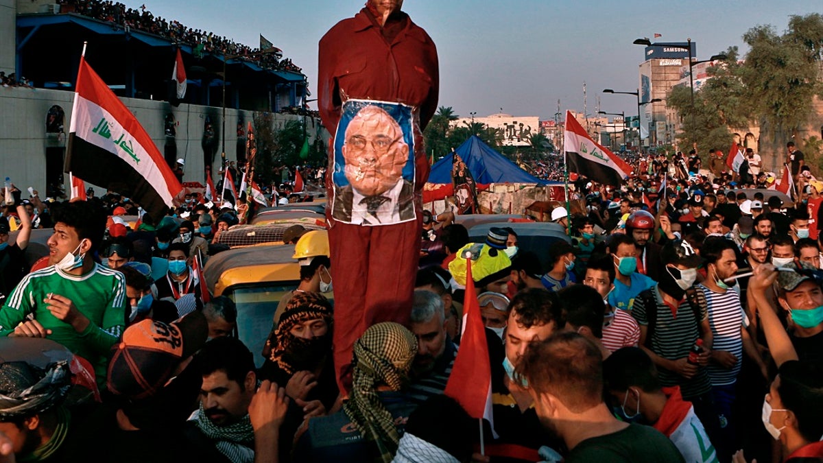 In this Wednesday, Oct. 30, 2019 file photo, anti-government protesters hold an effigy of Iraqi Prime Minister Adel Abdel-Mahdi during ongoing protests in Baghdad. Celebrations erupted in Iraq's Tahrir Square on Friday where anti-government protesters have been camped out for nearly two months following an announcement by Iraqi Prime Minister Adel Abdul-Mahdi, would be resigning. (AP Photo/Khalid Mohammed, File)