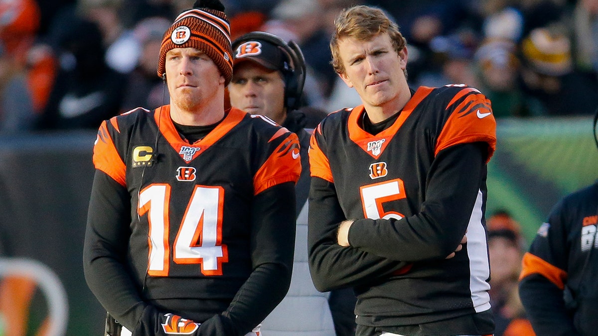 Cincinnati Bengals quarterbacks Andy Dalton (14) and Ryan Finley (5) stand on the sidelines during the second half an NFL football game against the Pittsburgh Steelers, Sunday, Nov. 24, 2019, in Cincinnati. (AP Photo/Frank Victores)