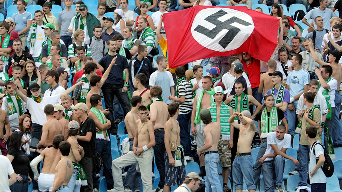 Supporters of Karpaty Lviv hold a German Nazi flag with a swastika as they attend a soccer match against Dynamo Kiev in Kiev August 19, 2007. Poland and Ukraine denounced British press allegations of racism and mob violence at soccer stadiums.