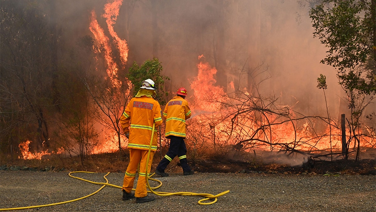 Firefighters tackle a bushfire to save a home in Taree, 350km north of Sydney on November 9, 2019 as they try to contain dozens of out-of-control blazes that are raging in the state of New South Wales. - At least two people have died and 100 homes have been destroyed as an unprecedented number of bushfires tore through eastern Australia. (Photo by PETER PARKS / AFP) (Photo by PETER PARKS/AFP via Getty Images)
