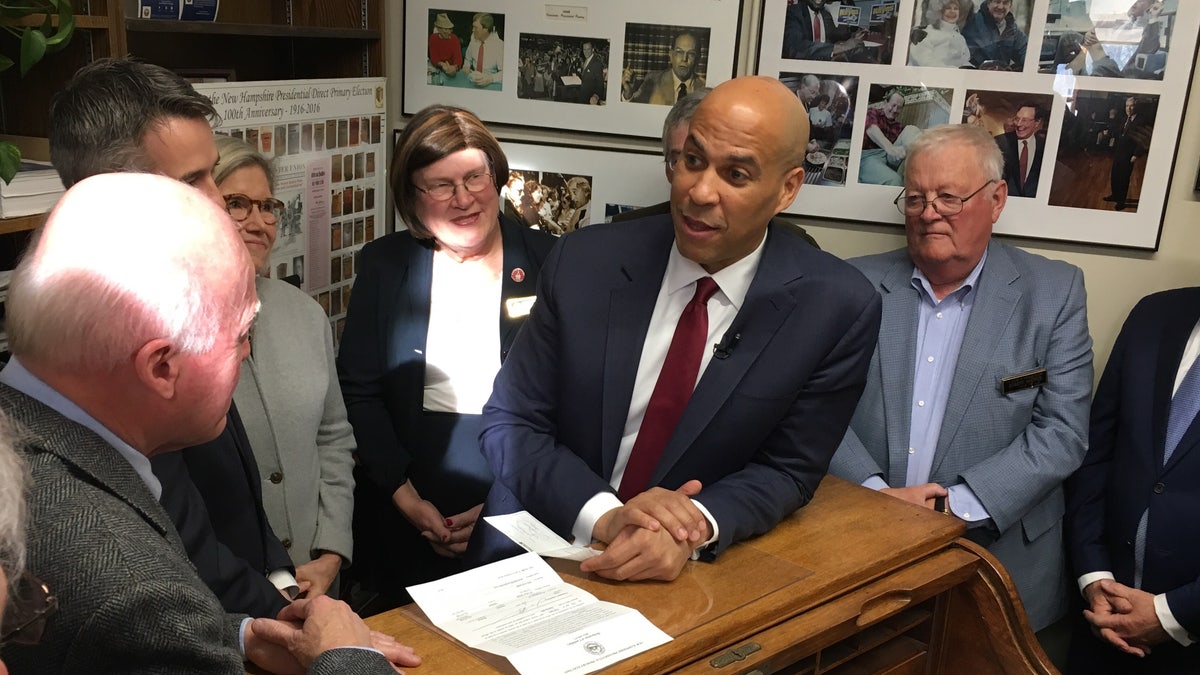 Democratic presidential candidate Sen. Cory Booker of New Jersey Statehouse hands over a $1,000 check to longtime New Hampshire Secretary of State Bill Gardner as he files place his name on the first-in-the-nation presidential primary, in Concord, NH on Nov. 15, 2019