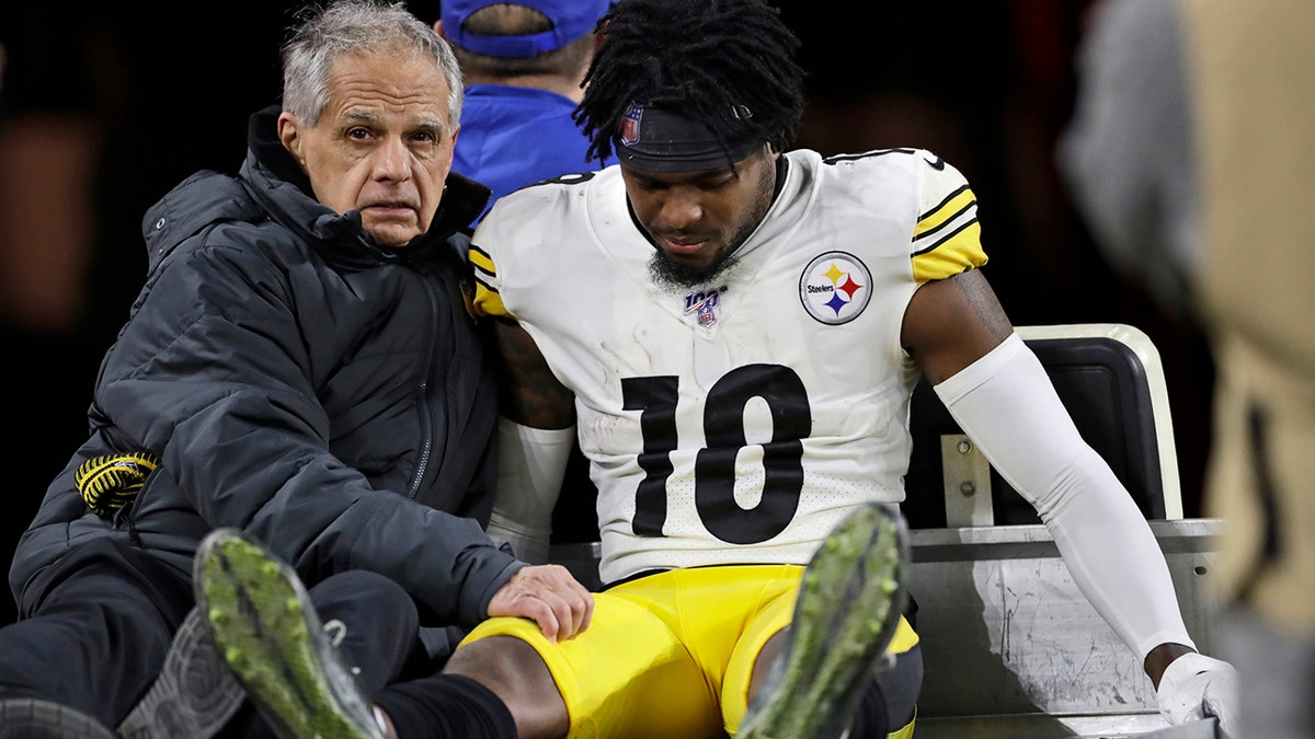 Pittsburgh Steelers wide receiver Diontae Johnson (18) carted back to the locker room after getting hit by Cleveland Browns strong safety Damarious Randall during the second half of an NFL football game, Thursday, Nov. 14, 2019, in Cleveland. Randall was ejected from the game.