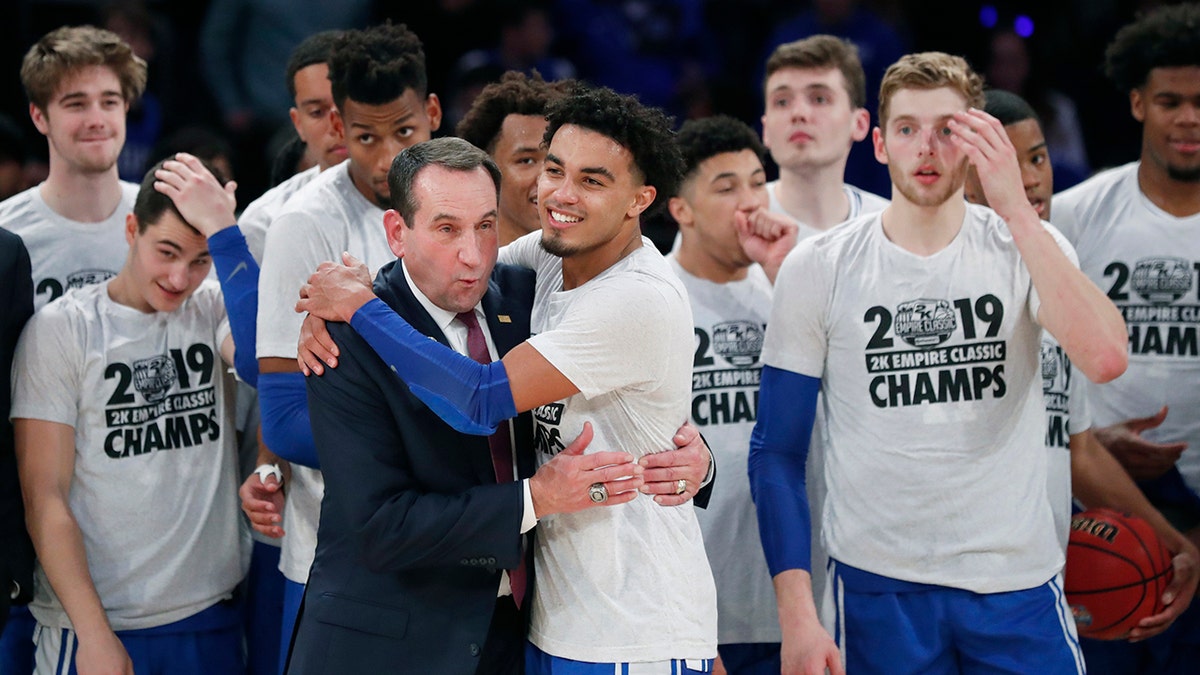 Duke guard Tre Jones (3) embraces coach Mike Krzyzewski after Duke defeated Georgetown 81-73 in an NCAA college basketball game in the 2K Empire Classic, Friday, Nov. 22, 2019 in New York. (AP Photo/Kathy Willens)