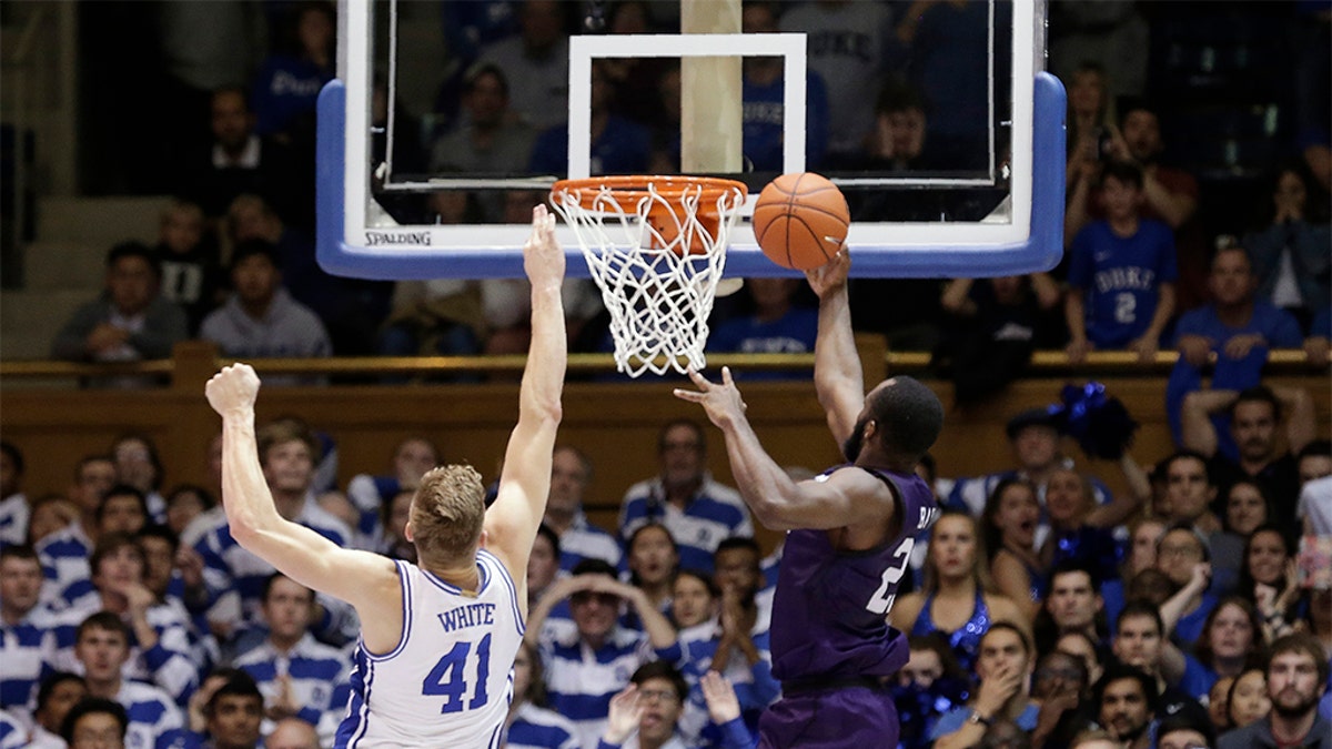 Stephen F. Austin forward Nathan Bain (23) made the game-winning basket over Duke forward Jack White (41) during overtime in an NCAA college basketball game on Tuesday. Stephen F. Austin won 85-83. (AP Photo/Gerry Broome)