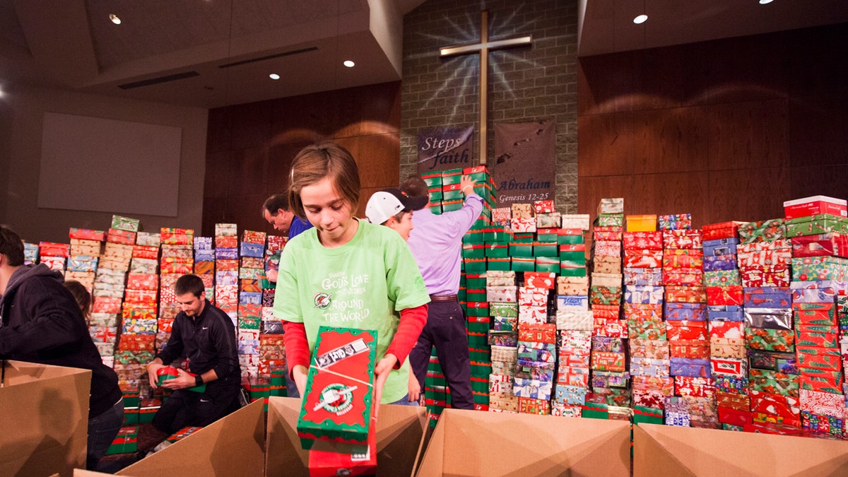 Evilyn Pinnow readies one of hundreds of Operation Christmas Child shoe box gifts to be processed and sent to children in more than 100 countries around the world.