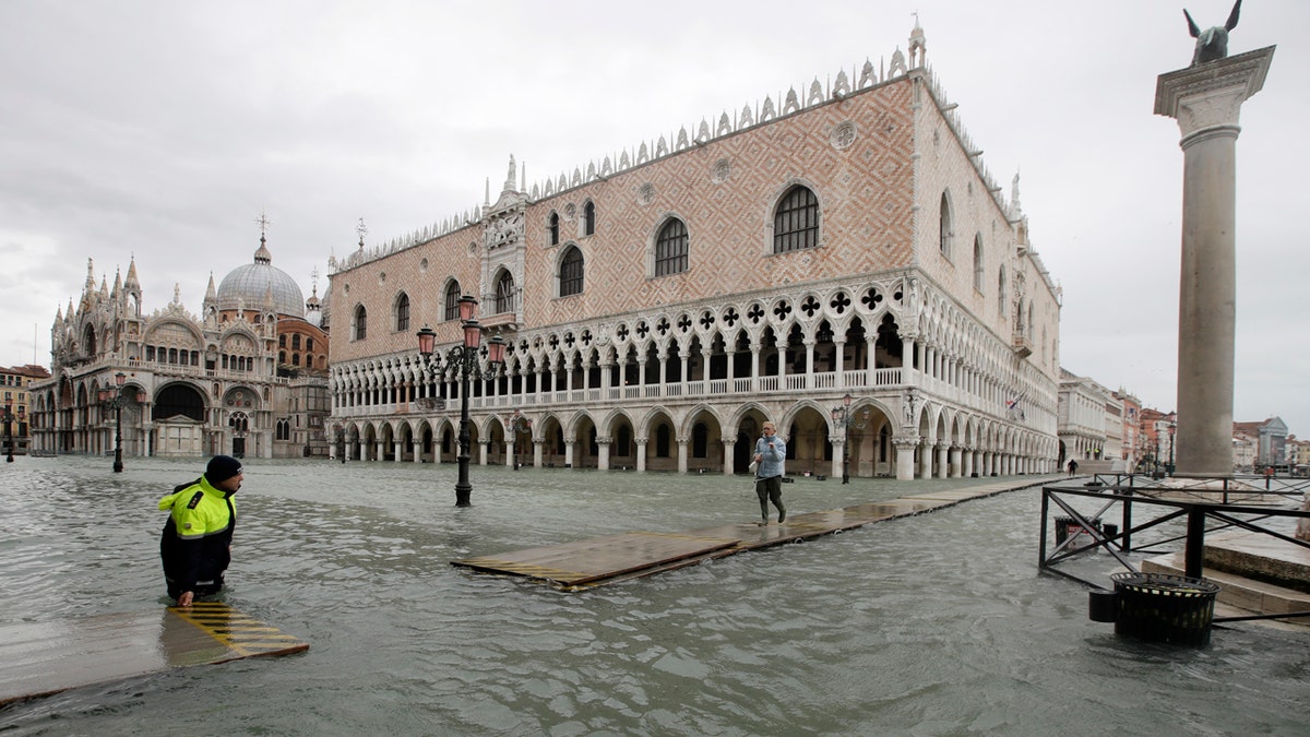 A woman arrives in St. Mark's Square on a gangway, in spite of a ban, in Venice, Italy, Sunday, Nov. 17, 2019.