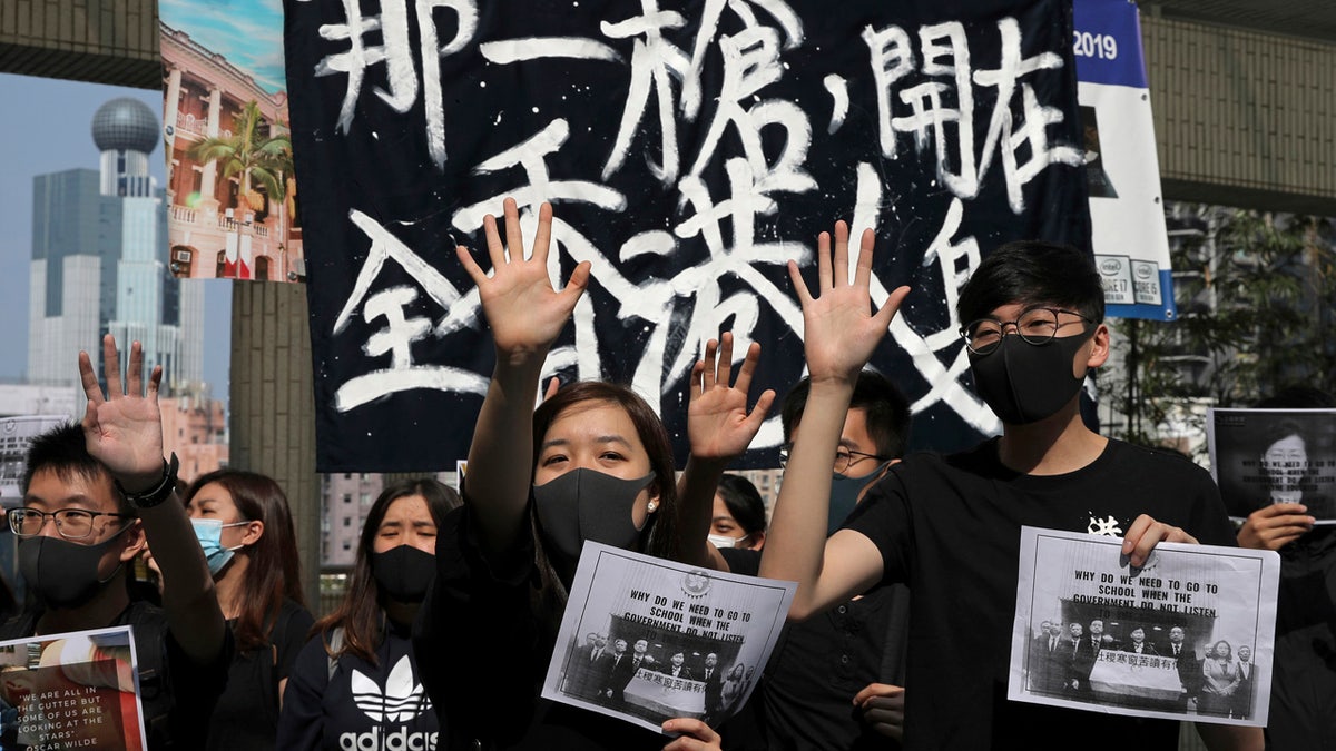 Pro-democracy students hold up their hands representing five demands at the University of Hong Kong, Wednesday, Nov. 6, 2019, as they rally against police brutality.