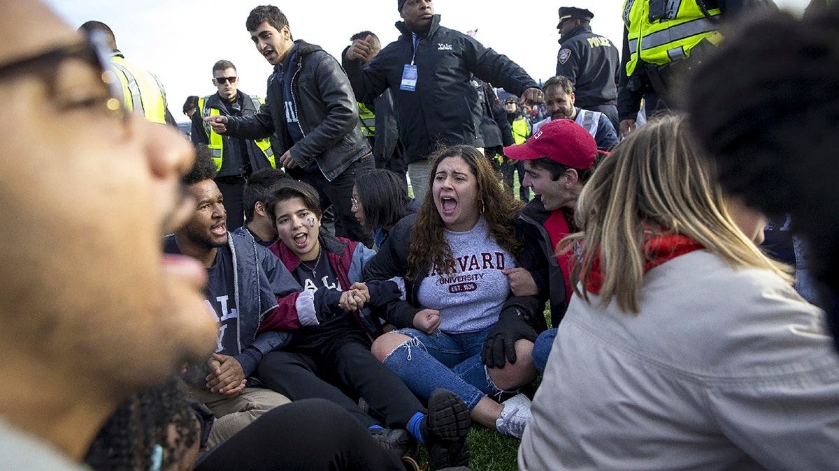 Harvard and Yale students protest during halftime of the NCAA college football game between Harvard and Yale at the Yale Bowl in New Haven, Conn., on Nov. 23, 2019. (Nic Antaya/The Boston Globe via AP)