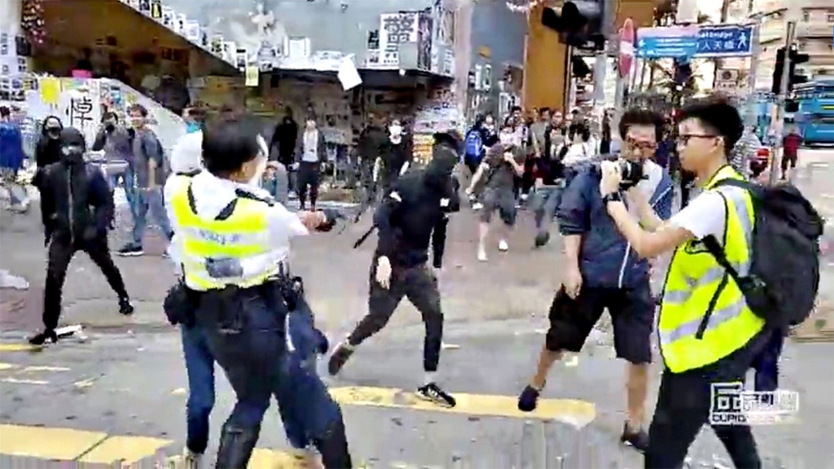 A still image from video showed a police officer aiming his gun as a protester in Hong Kong on Monday morning.