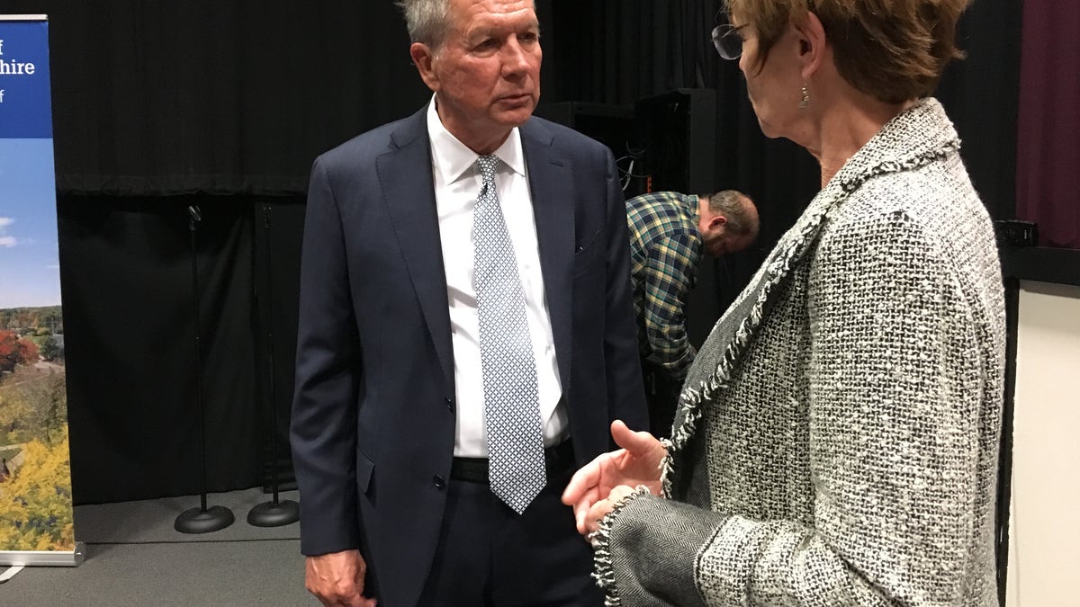 Former Ohio Gov. John Kasich speaks to an audience member after a book tour event at the University of New Hampshire in Durham, N.H., on Nov. 7, 2019.