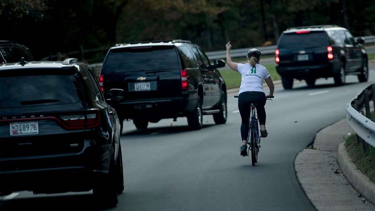  Juli Briskman gestures with her middle finger as a motorcade with President Trump passes by in Virginia in 2017. (Getty Images)