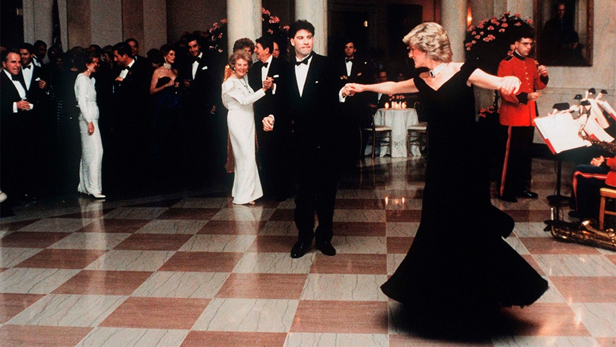 Princess Diana dances with actor John Travolta in a dress designed by Victor Edelstein, whilst attending a State Dinner at the White House in 1985.