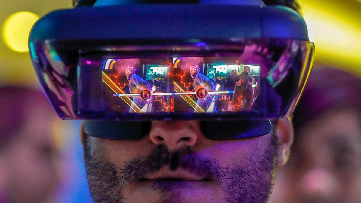 A visitor tries out Lenovo augmented reality glasses with the Star Wars Jedi Challenges during the Mobile World Congress in Barcelona, Spain, February 26, 2018. REUTERS/Yves Herman TPX IMAGES OF THE DAY - RC1EAA1E2450