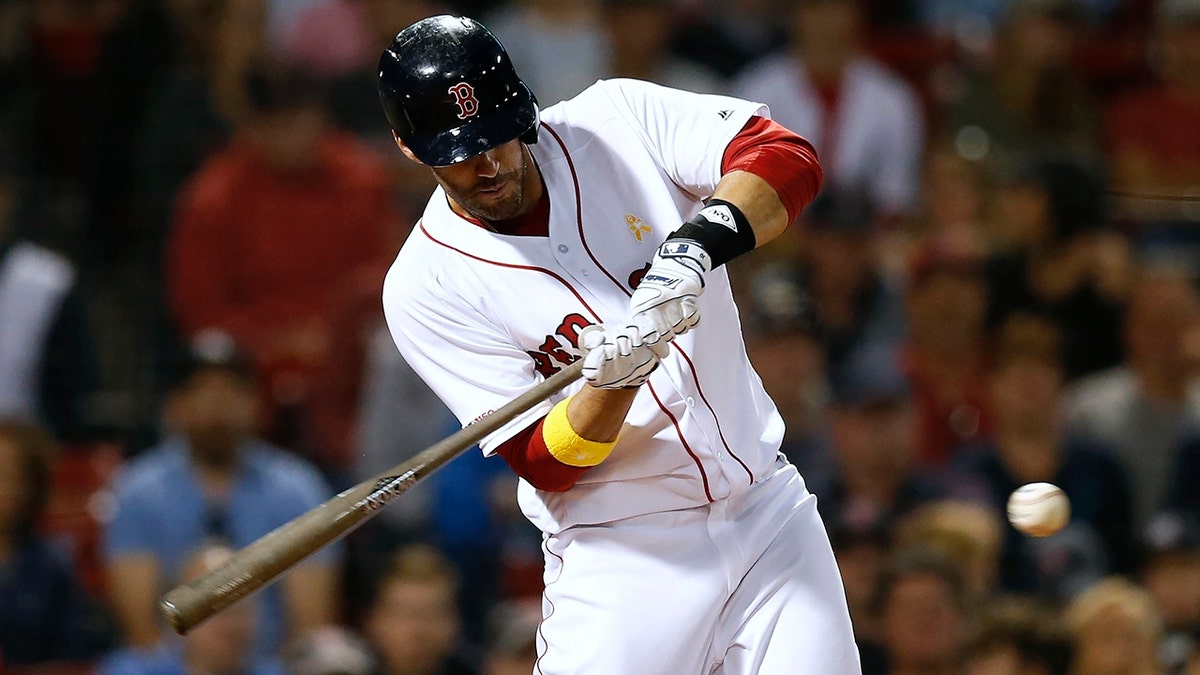 FILE - In this Sept. 7, 2019, file photo, Boston Red Sox's J.D. Martinez hits a solo home run during the ninth inning of a baseball game against the New York Yankees in Boston. Red Sox designated hitter Martinez has decided to keep his contract with the team instead of becoming a free agent again. (AP Photo/Michael Dwyer, File)