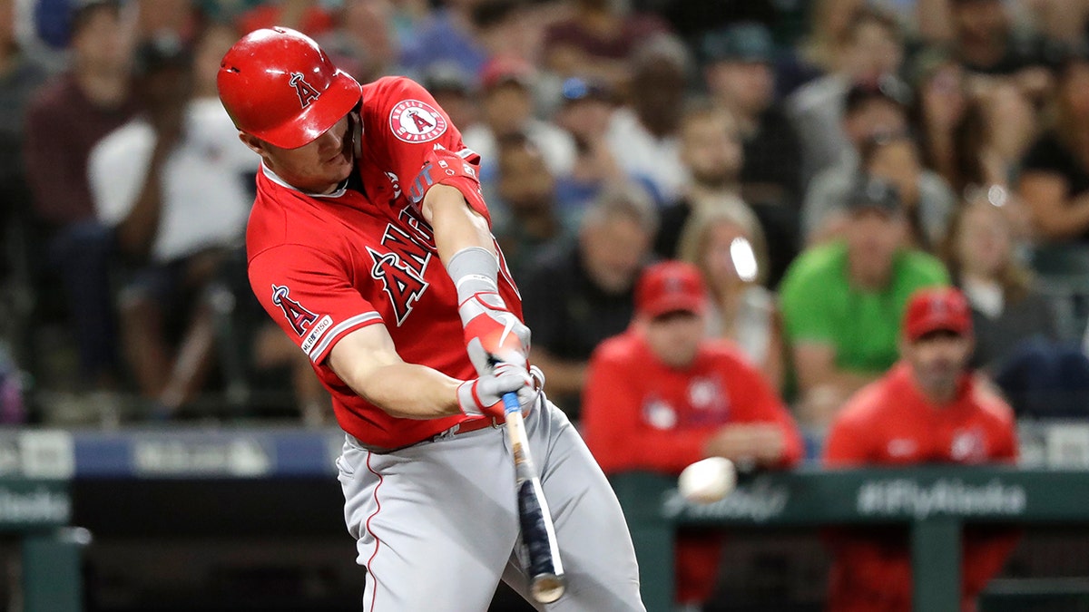 FILE - In this July 20, 2019, file photo, Los Angeles Angels' Mike Trout connects on a three-run home run against the Seattle Mariners in the ninth inning of a baseball game in Seattle. Angels outfielder Trout, Houston Astros third baseman Alex Bregman and Oakland Athletics shortstop Marcus Semien are finalists for the AL MVP award, and Washington Nationals third baseman Anthony Rendon, Los Angeles Dodgers outfielder Cody Bellinger and Milwaukee Brewers outfielder Christian Yelich are the top three for the NL honor. (AP Photo/Elaine Thompson, File)