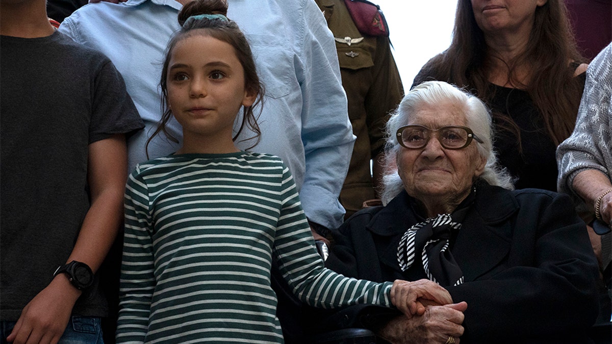 Melpomeni Dina holding the hand of an Israeli girl during a reunion at the Yad Vashem Holocaust memorial in Jerusalem on Sunday.