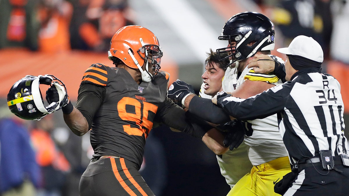 Cleveland Browns defensive end Myles Garrett, left, gets ready to hit Pittsburgh Steelers quarterback Mason Rudolph, second from left, with a helmet during the second half of an NFL football game Thursday, Nov. 14, 2019, in Cleveland.