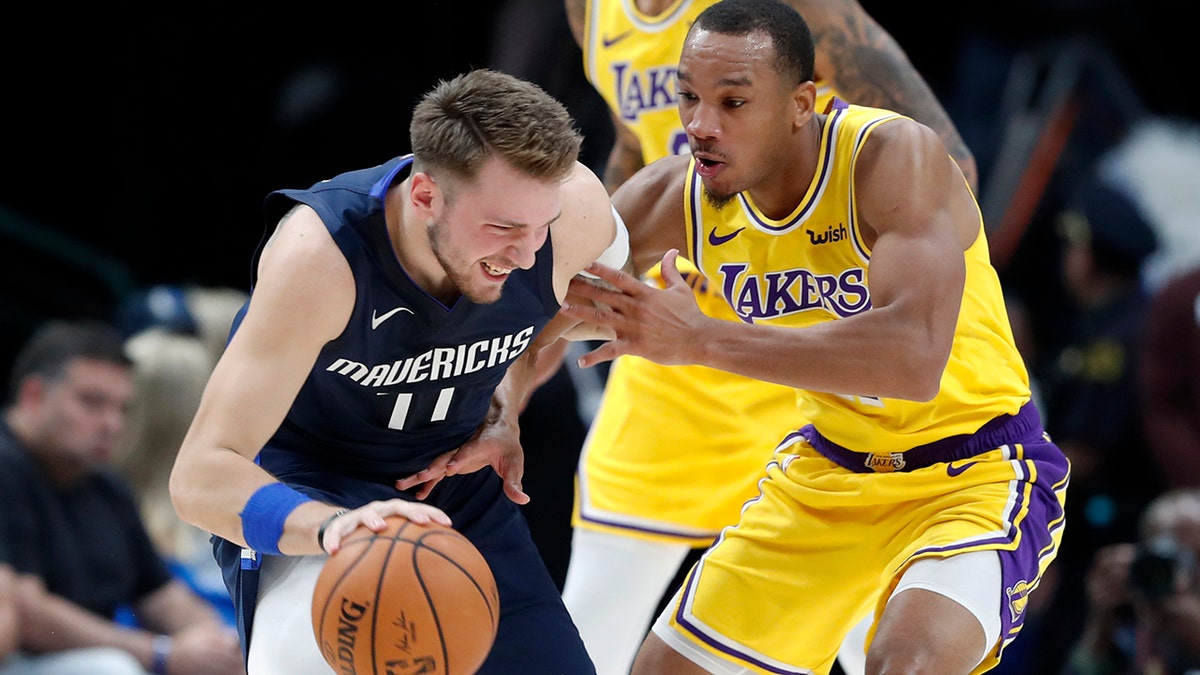 Dallas Mavericks' Luka Doncic, left, works against Los Angeles Lakers' Avery Bradley during the first half of an NBA basketball game in Dallas, Friday, Nov. 1, 2019. (AP Photo/Tony Gutierrez)