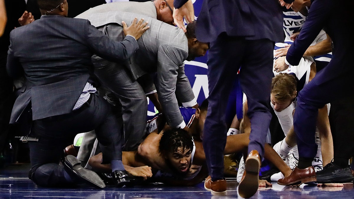 Minnesota Timberwolves' Karl-Anthony Towns lies on the court after an altercation with Philadelphia 76ers' Joel Embiid during the second half of an NBA basketball game Wednesday, Oct. 30, 2019, in Philadelphia. Both players were ejected. The 76ers won 117-95. (AP Photo/Matt Rourke)