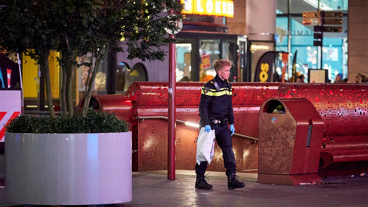 A Dutch police officer secures a bag with items from the scene of a stabbing incident in the center of The Hague, Netherlands. (AP Photo/Phil Nijhuis)