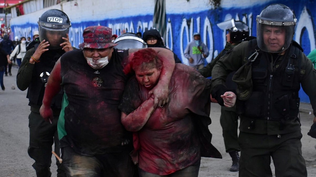 Police rescue Vinto mayor Patricia Arce Guzman after people threw paint and dirt on her following a fire in Vinto's Town Hall, Quillacollo, Bolivia, November 6, 2019, in this image obtained from Los Tiempos Bolivia social media.