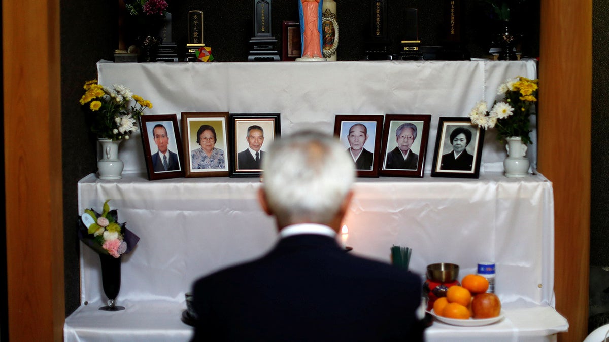 Shigenori Murakami, 69, the seventh-generation head of a group of 'Hidden Christians' chants 'orasho' in front of an altar adorned with a statue of the Virgin Mary and photos of deceased relatives at his home in Nagasaki, southern Japan, November 3, 2019. REUTERS/Issei Kato SEARCH