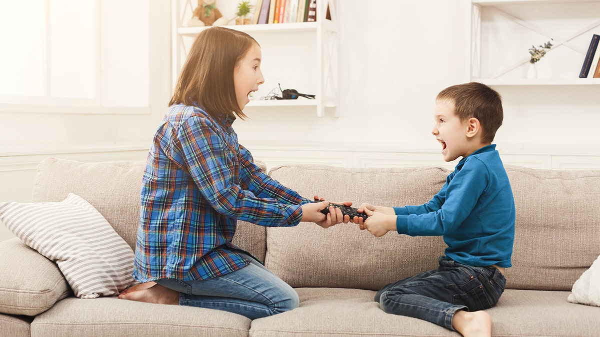 Siblings fighting over remote control at home, brother and sister have quarrel, copy space. (Photo: iStock)