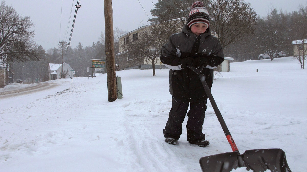 Kaiden Rogers shovels snow from his driveway on Tuesday, Nov. 12, 2019 in Marshfield, Vt.