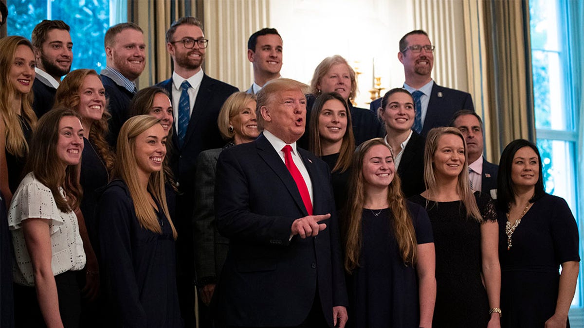 President Donald Trump stands with members of Queens University of Charlotte Swim Team during the NCAA Collegiate National Champions Day at the White House, Friday, Nov. 22, 2019, in Washington.