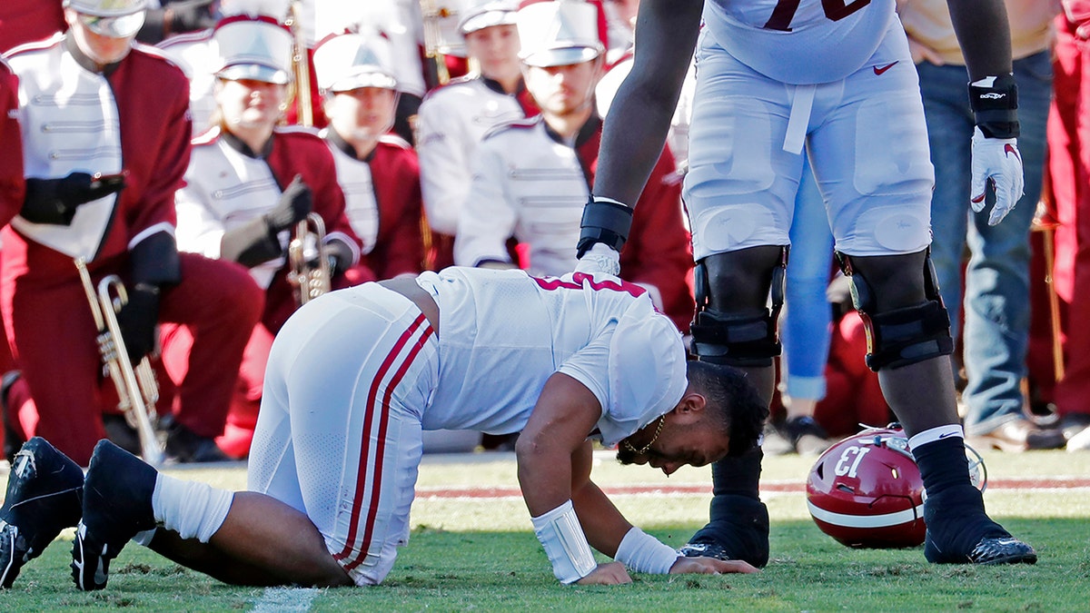Alabama sive lineman Alex Leatherwood (70) checks on quarterback Tua Tagovailoa (13) after he was injured in the first half of an NCAA college football game against Mississippi State in Starkville, Miss., Saturday, Nov. 16, 2019. Alabama won 38-7. (AP Photo/Rogelio V. Solis)