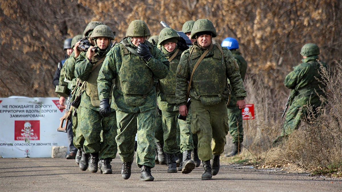 A Russia-backed separatist rebels' unit walks to take its position at the new line of contact outside Petrivske, Ukraine, Saturday, Nov. 9, 2019. 