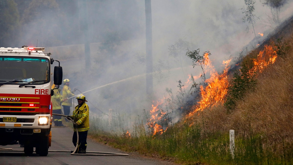 In Monday, Nov. 11, 2019, photo, firefighters work on a controlled burn in Koorainghat, New South Wales state, Australia.