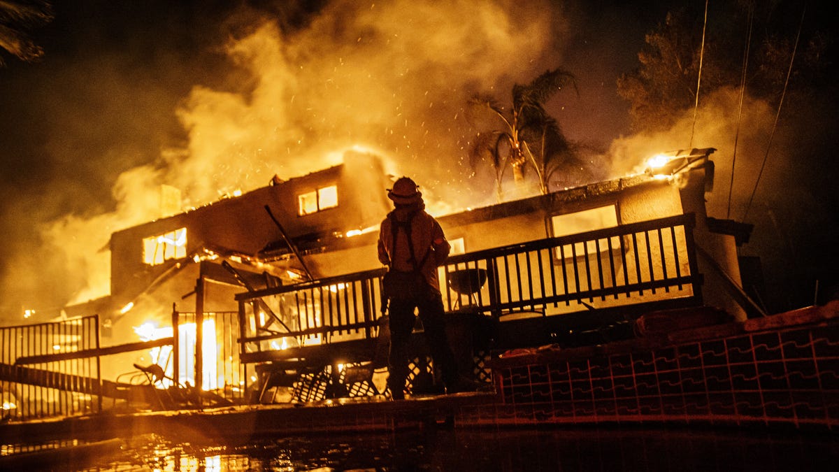 Firefighters work to control the flames as the embers blown by the wind threaten more homes in the North Park neighborhood at the Hillside Fire in San Bernardino on Thursday. (Photo by Marcus Yam/Los Angeles Times via Getty Images)