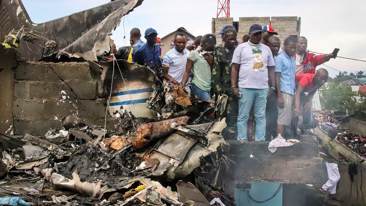 Rescuers and onlookers gather amidst the debris of an aircraft that crashed in Goma, Congo on Sunday. (AP Photo/Justin Kabumba)