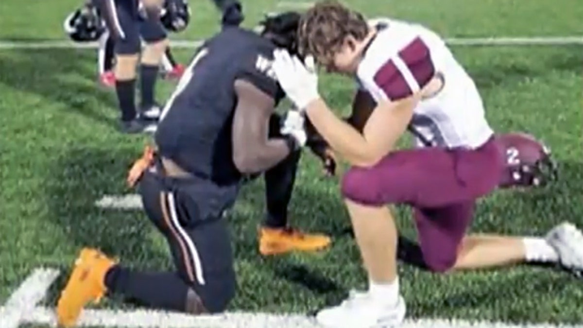 Sherman High School senior Gage Smith was seen kneeling down with West Mesquite High School player Ty Jordan as they prayed for Jordan’s mother, who is battling cancer.