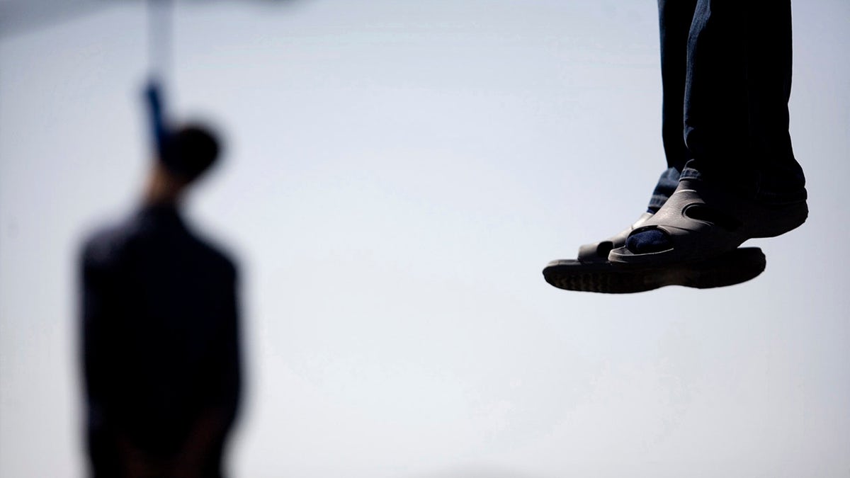 Majid Kavousifar and Hossein Kavousifar, his nephew, hang from the cable of a crane in Tehran, Aug. 2, 2007. Iran hanged Majid and Hossein, the killers of a judge who had jailed several reformist dissidents, before a crowd of hundreds of people. 