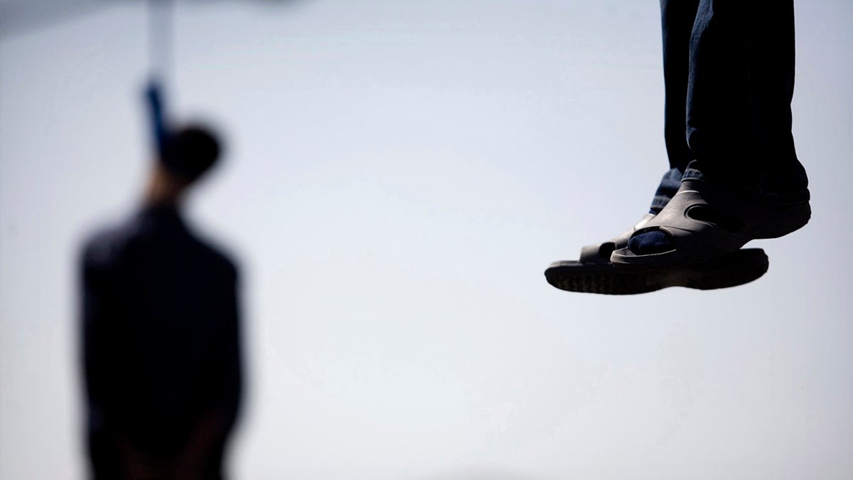 Majid Kavousifar and Hossein Kavousifar, his nephew, hang from the cable of a crane in Tehran, Aug. 2, 2007. Iran hanged Majid and Hossein, the killers of a judge who had jailed several reformist dissidents, before a crowd of hundreds of people.