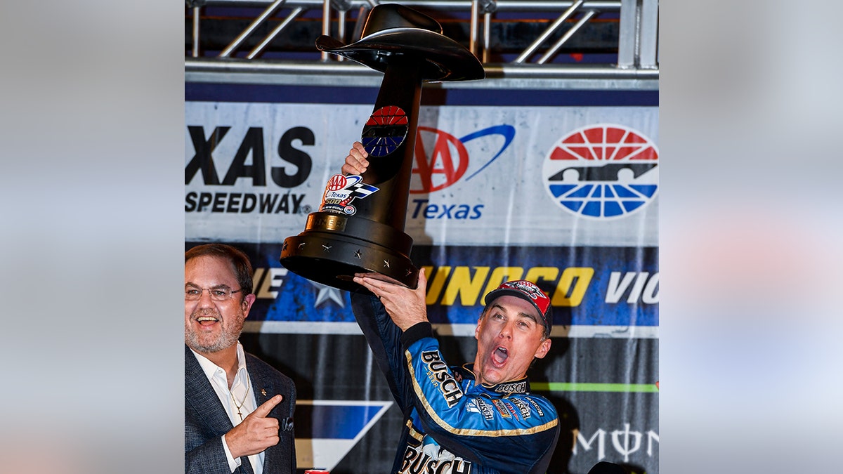 Kevin Harvick celebrates with the trophy in Victory Lane after winning a NASCAR Cup Series auto race at Texas Motor Speedway, Sunday, Nov. 3, 2019, in Fort Worth, Texas. (AP Photo/Larry Papke)