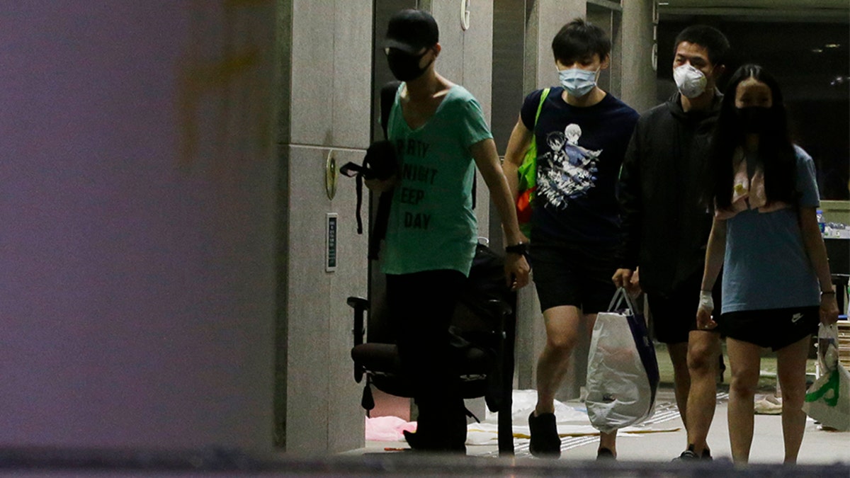 Protesters walk inside the campus of Polytechnic University in Hong Kong on Friday. Most of the protesters who took over the university last week have left, but an unknown number have remained inside for days, hoping somehow to avoid arrest. (AP)