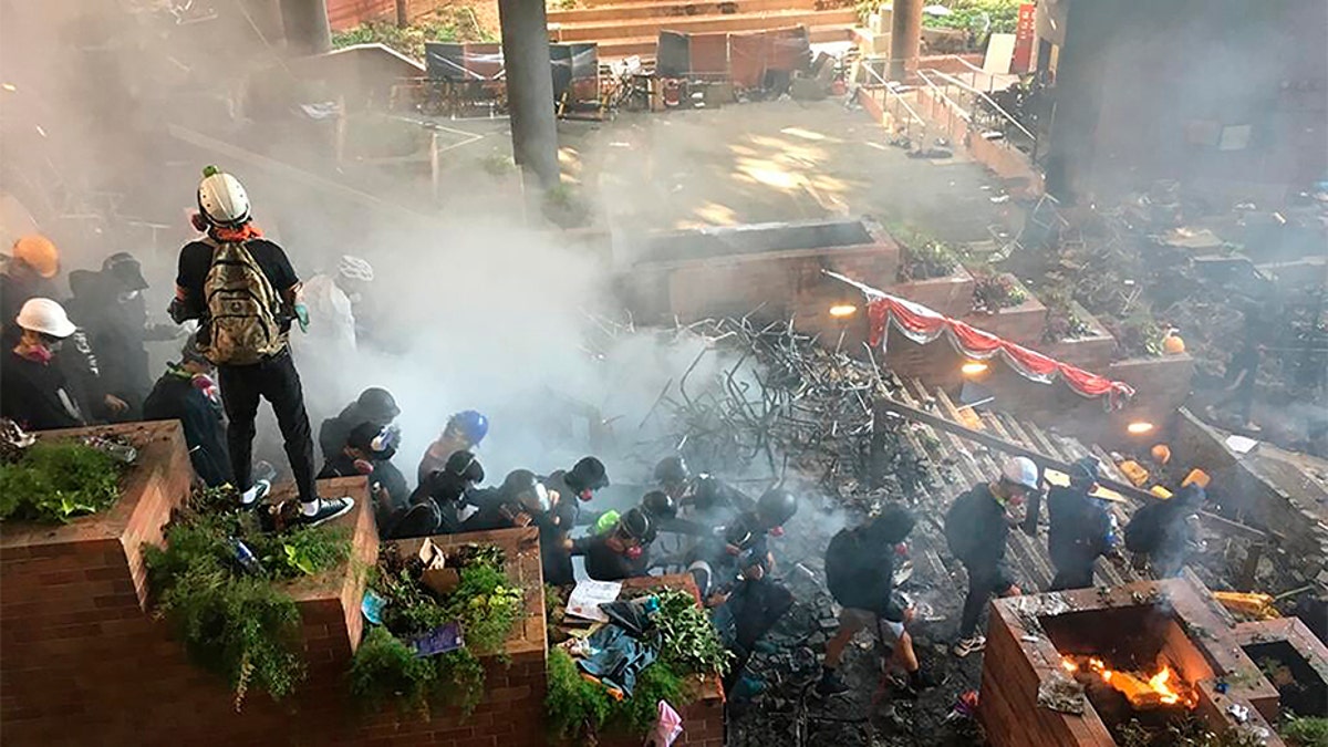 Protesters go down the steps at the front entrance of Hong Kong Polytechnic University in Hong Kong in an attempt to flee Monday.