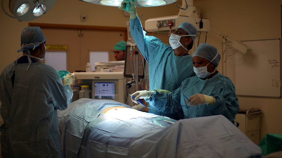A surgical team prepare a patient ahead of performing an operation at Milton Keynes University Hospital in Milton Keynes, central England, Britain, May 23, 2018. A recent report shows England's NHS system is failing to meet several of its standards regarding patient wait times.
