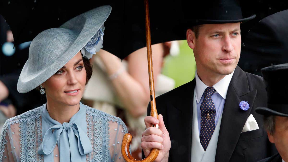 Catherine, Duchess of Cambridge and Prince William, Duke of Cambridge shelter under an umbrella as they attend day one of Royal Ascot at Ascot Racecourse.