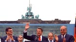 FILE - In this on Friday, June 12, 1987 file photo, U.S. President Ronald Reagan acknowledges the applause after speaking to an audience in front of the Brandenburg Gate in Berlin. Beside Reagan are the President of the German Parliament Philipp Jenninger, left, and Germanys Chancellor Helmut Kohl, right. The U.S. Embassy in Berlin is unveiling the statue of Ronald Reagan as a tribute to the 30th anniversary of the fall of the Berlin Wall. The larger-than-life statue is being installed Friday atop the embassys terrace, at eye-level with the landmark Brandenburg Gate in downtown Berlin. (AP PHOTO/Ira Schwartz, File)