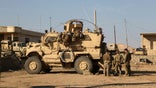In this Feb. 23, 2017 photo, U.S. Army soldiers stand outside their armored vehicle on a joint base with Iraqi army south of Mosul, Iraq. Iraqi security officials say 17 Katyusha rockets have hit an Iraqi air base south of the city of Mosul that houses American troops. The two officials say there are no immediate reports of casualties from the attack, which occurred on Friday. (AP Photo/ Khalid Mohammed, File)
