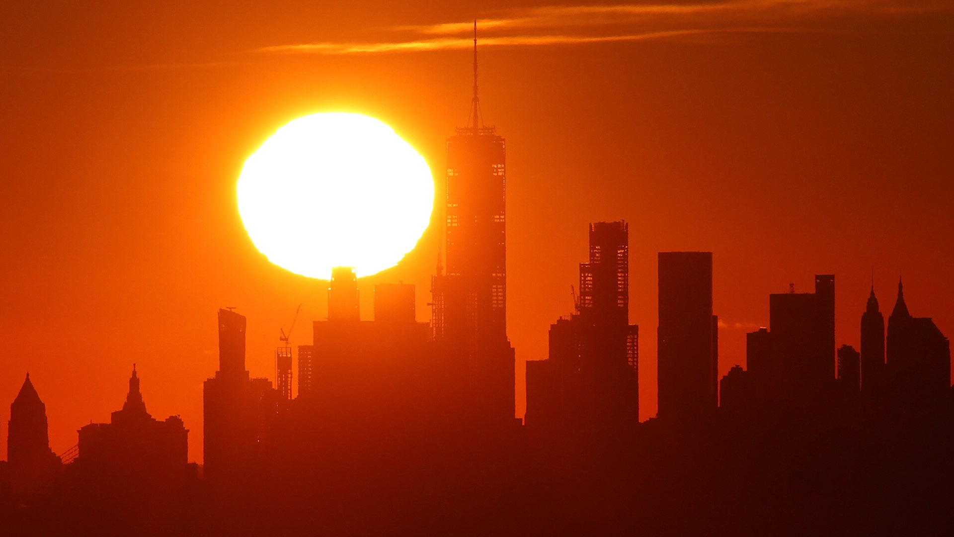 The sun rises behind lower Manhattan and One World Trade Center in New York City, Nov. 23, 2019.